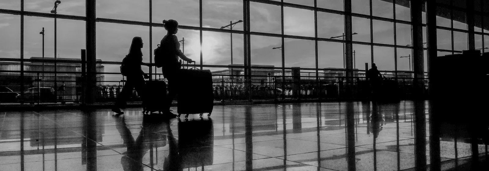 Travellers walking with suitcases through Barcelona–El Prat Airport